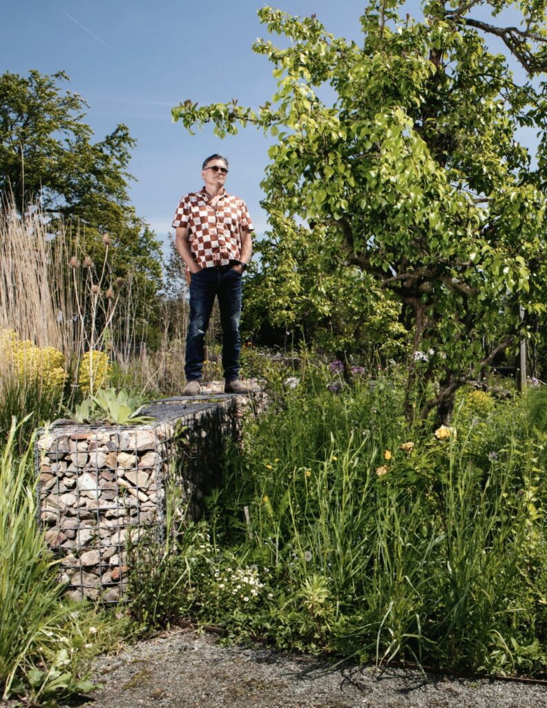 John Little stands on a gabion with which he is experimenting to see what plants will thrive in such inhospitable terrain
